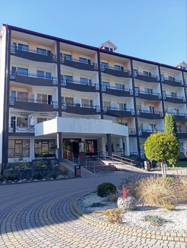 a large apartment building with a courtyard in front of it at Girska Tysa Health Resort in Kvasy