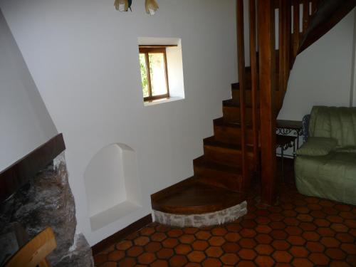 un salon avec un escalier et un canapé vert dans l'établissement La Maison du Sabotier, à Corancy