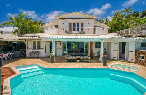 a villa with a swimming pool in front of a house at Villa spa Grand Anse in Petite Île