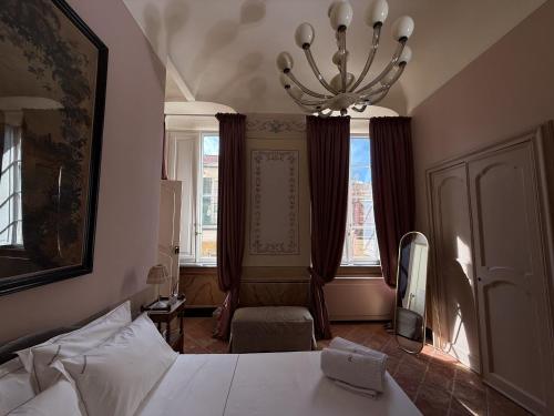a bedroom with a bed and a chandelier at PALAZZO RICARDI Chambres d'hotes in Imperia