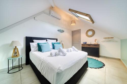 a bedroom with a large white bed with blue pillows at Kaz d Abord in Saint-Pierre