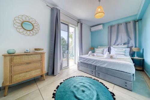 a blue bedroom with a bed and a large window at Kaz d Abord in Saint-Pierre