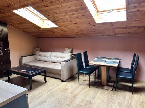 a living room with a couch and a table and chairs at Готель-ресторан Chalet in Bila Tserkva