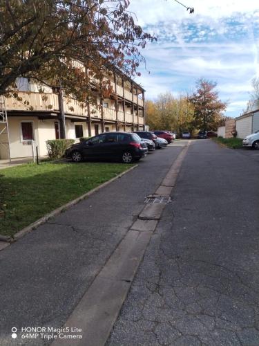 a street with cars parked in front of a building at Hotel et Residence Moissy Cramayel in Moissy-Cramayel