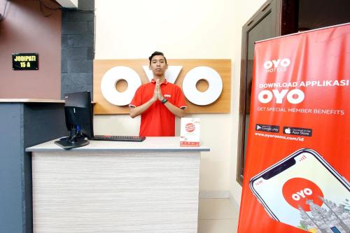 a man standing at a booth at an ovo event at Hotel O near UGM formerly Bayang Brothers Guest House in Yogyakarta
