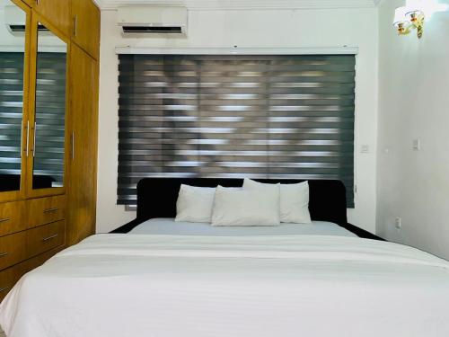 1 dormitorio con 1 cama blanca grande frente a una ventana en Modern 1bedroom in Bodija, en Ibadán