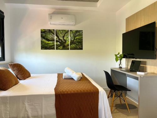 a bedroom with a bed and a desk with a computer at Aptos 1 ou 2 quartos no Centro com Piscina e Academia in Maringá