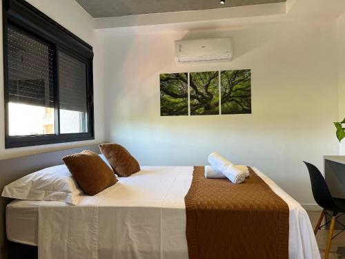 a bedroom with a bed and a window at Aptos 1 ou 2 quartos no Centro com Piscina e Academia in Maringá