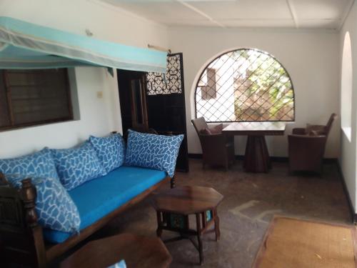 Una sala de estar con un sofá azul y una mesa. en Allison Homes, en Kilifi