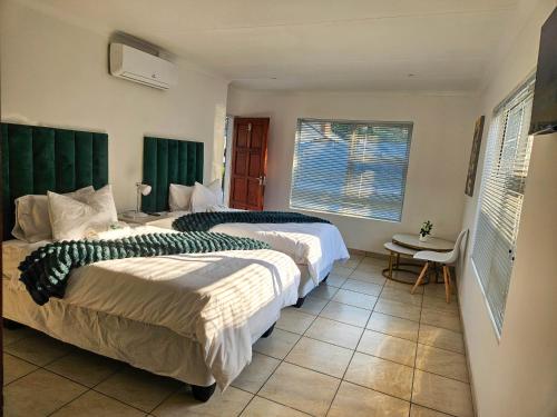 - une chambre avec 2 lits et des têtes de lit vertes dans l'établissement The M GuestHouse, à Kempton Park