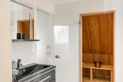 a white kitchen with a sink and a mirror at Perle von Borkum 2 in Borkum