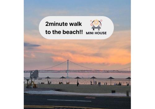 a view of the beach with a bridge in the background at Mini House in Busan