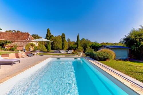 a swimming pool in the yard of a house at Lodge La Forêt in Saint-Sauveur