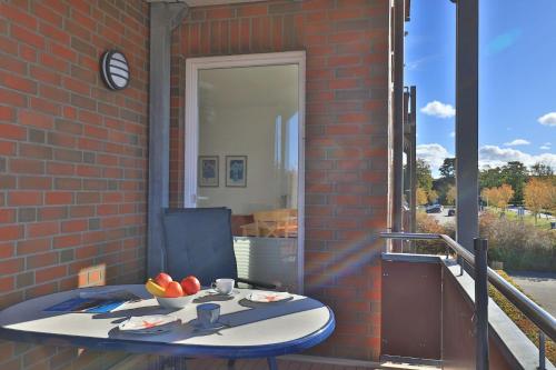 a table on a balcony with a bowl of fruit on it at Kastanienhof Whg 07 in Boltenhagen