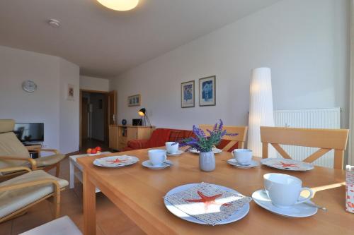 a table with cups and saucers on it in a living room at Kastanienhof Whg 07 in Boltenhagen