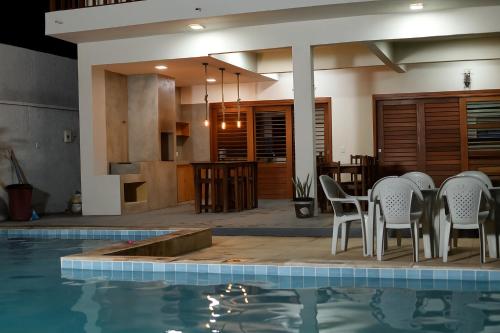 a house with a swimming pool and a table and chairs at Casa da GabiLu in Itapipoca