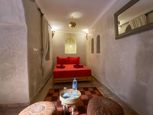 a bedroom with a red bed and a table at Riad Prada in Marrakech