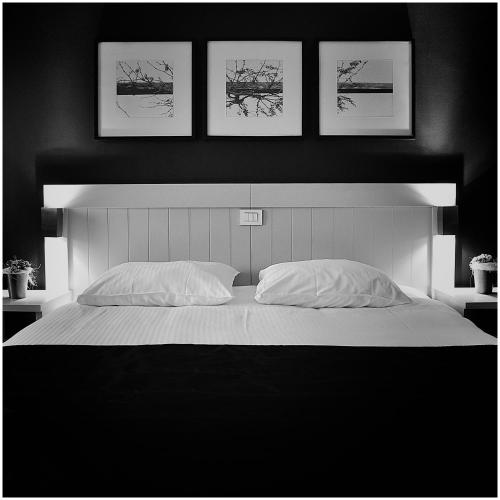 a bedroom with a large bed with four pictures on the wall at Hotel Florent in Lier