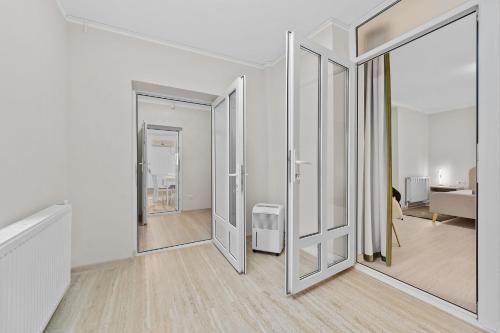 una stanza con pareti bianche e porte scorrevoli in vetro di Casa Albă a Roman