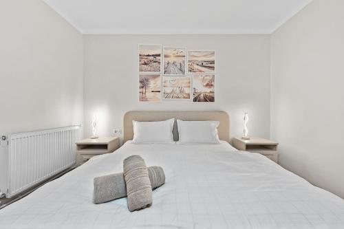 una camera da letto con un grande letto bianco con due cuscini di Casa Albă a Roman