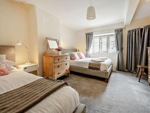 a bedroom with two beds and a dresser and a window at 4 Bed in Buttermere SZ090 in Buttermere