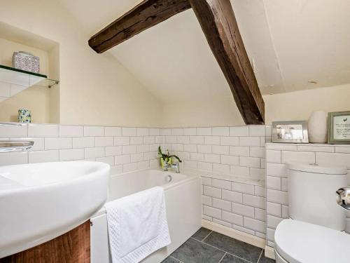 a white bathroom with a tub and a sink at 4 Bed in Buttermere SZ090 in Buttermere