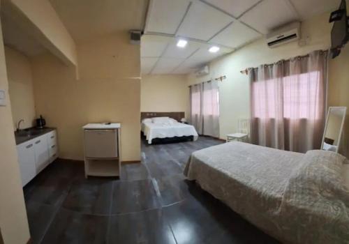 a hotel room with two beds and a bathroom at Apart hotel Amter in Fray Bentos