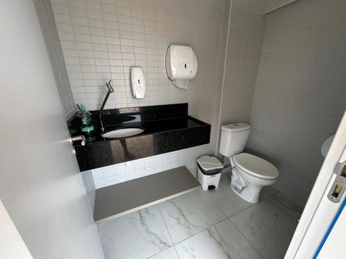 a bathroom with a toilet and a sink and a phone at Flat Premium no Centro de Porto de Galinhas - Próximo as piscinas naturais in Porto De Galinhas