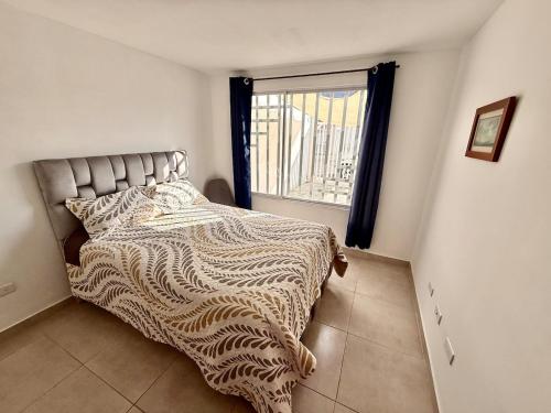 a bedroom with a large bed with a window at Ideal para familia de 5 in Ibarra