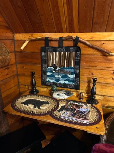a table in a room with a book and a picture at The Drake Cabin in The Forest in Cosby