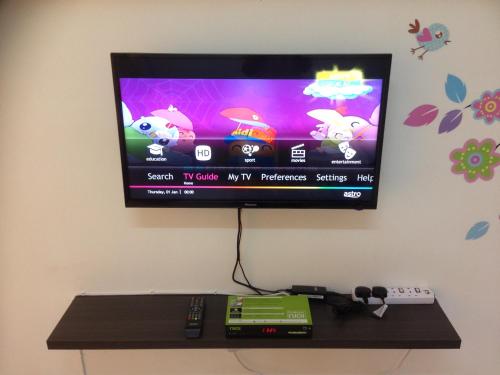 a flat screen tv hanging on a wall at Super Cozy Homestay in Melaka