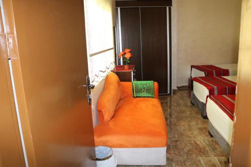 pomarańczowa kanapa w pokoju z dwoma łóżkami w obiekcie Premium apartment Section A w mieście Wadi Musa