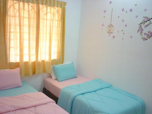 a room with two beds and a window at Super Cozy Homestay in Melaka