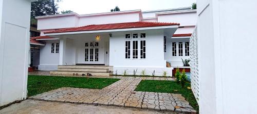 a white house with a red roof at Heaven Cloud Stay Hub Attappadi in Attappādi