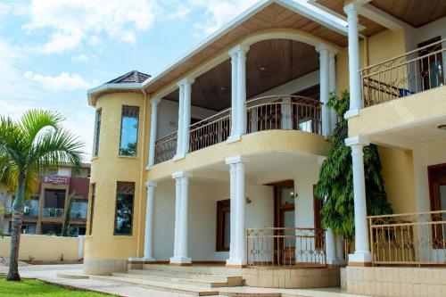 a large yellow house with a balcony at Elegant Villa Apart in Kigali