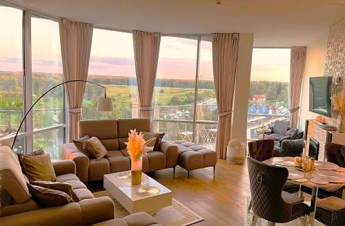 パランガにあるBlueSeaPearl apartamentai Palanga, Šventojiのソファと大きな窓のあるリビングルーム