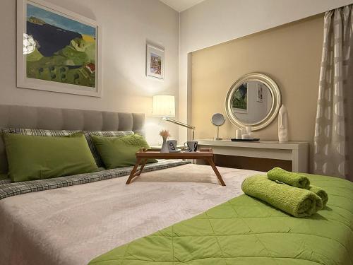 ein Schlafzimmer mit einem Bett, einem Tisch und einem Spiegel in der Unterkunft Στην ΚΑΡΔΙΑ ΤΗΣ ΠΟΛΗΣ - in the HURT OF THE TOWN in Tríkala