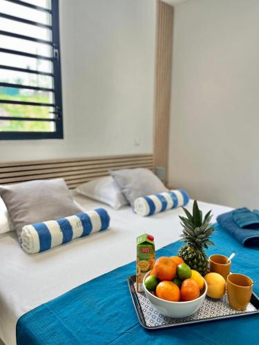 a tray with a bowl of fruit on a bed at Villa Aloha - classée 5 étoiles - avec piscine in Les Trois-Îlets