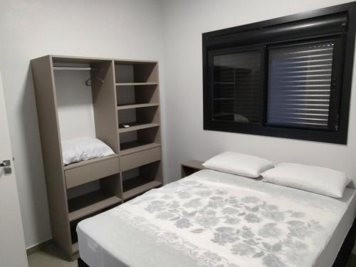 a small bedroom with a bed and a window at Paraiso das ondas primeira quadra do mar in Balneário Gaivotas