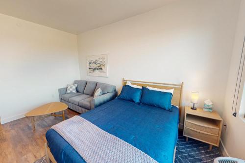a bedroom with a blue bed and a couch at Pioche Village - #1230 in Cranmer