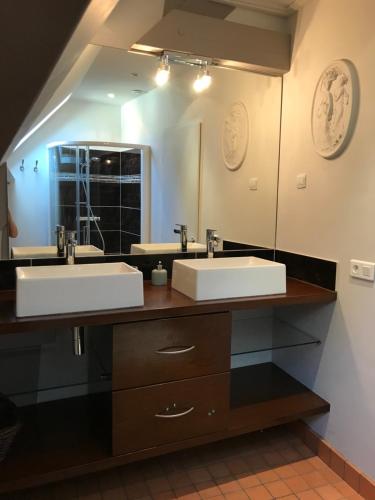 a bathroom with two sinks and a large mirror at Maison en pierre in Saint-Sozy