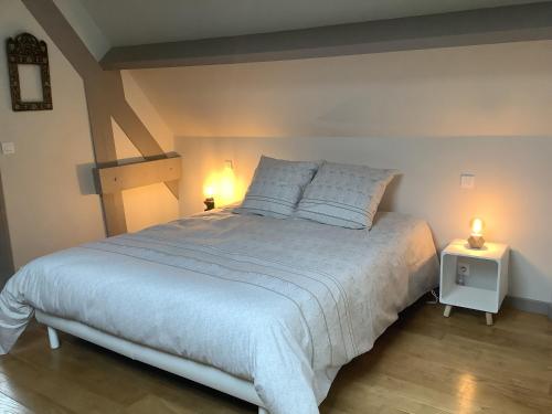a bedroom with a large bed with two lights on it at Maison en pierre in Saint-Sozy