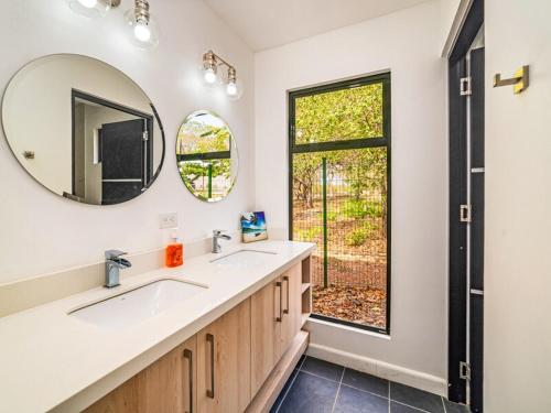 a bathroom with two sinks and a mirror and a window at The Wave House in Santa Cruz