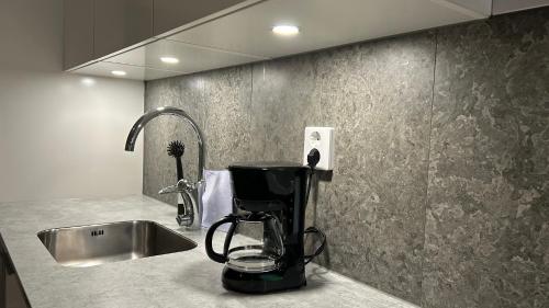 una cafetera sentada en un mostrador junto a un fregadero en Togton Comfort Nights Wifi, en Växjö