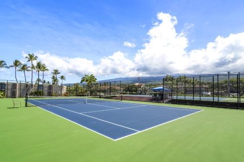 a tennis court with palm trees in the background at Kona Makai 2103 in Kailua-Kona