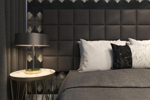 a bedroom with a bed and a table with a lamp at Silkari Suites at Chatswood in Sydney