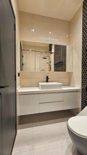 a white bathroom with a sink and a toilet at Oceara Dharavandhoo in Dharavandhoo