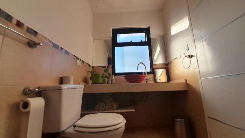 a small bathroom with a toilet and a window at Duplex Villa Carlos Paz in Villa Carlos Paz