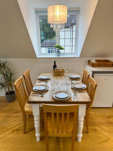 a dining room table with chairs and a chandelier at New Modern Studio in Chandlers Ford with Parking in Chandlers Ford