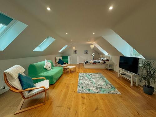 a living room with a green couch and a tv at New Modern Studio in Chandlers Ford with Parking in Chandlers Ford